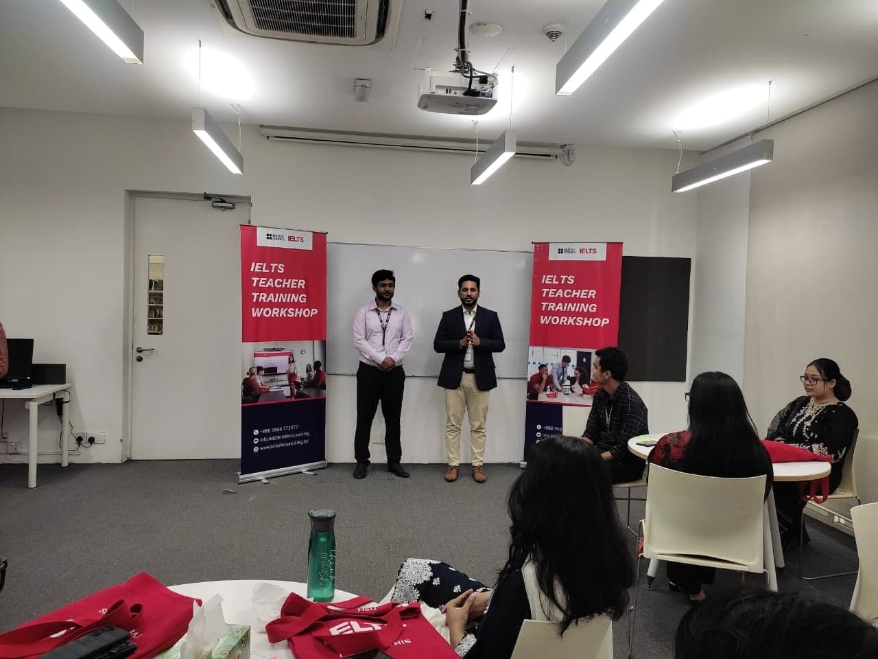 Two trainers presenting to a room of education professionals at a workshop.